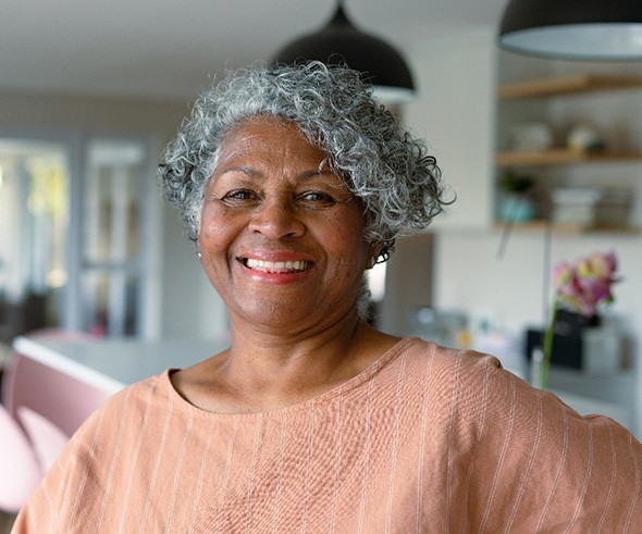 Senior woman in light pink shirt smiling