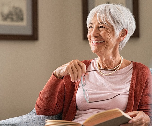 Woman smiling while reading at home