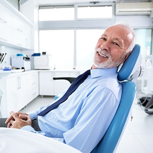 Senior man with tie leaning back in dental chair