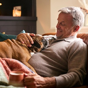 Man relaxing at home and petting his dog