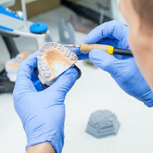 Lab technician customizing a set of dentures