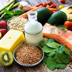 Various foods representing multiple food groups on wooden surface
