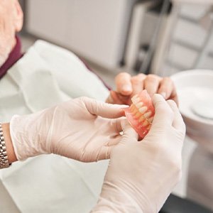 Dentist providing patient with their new dentures