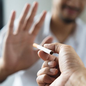 Man holding out hand to reject the offer of a cigarette