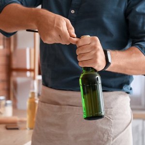 Man opens bottle with opener