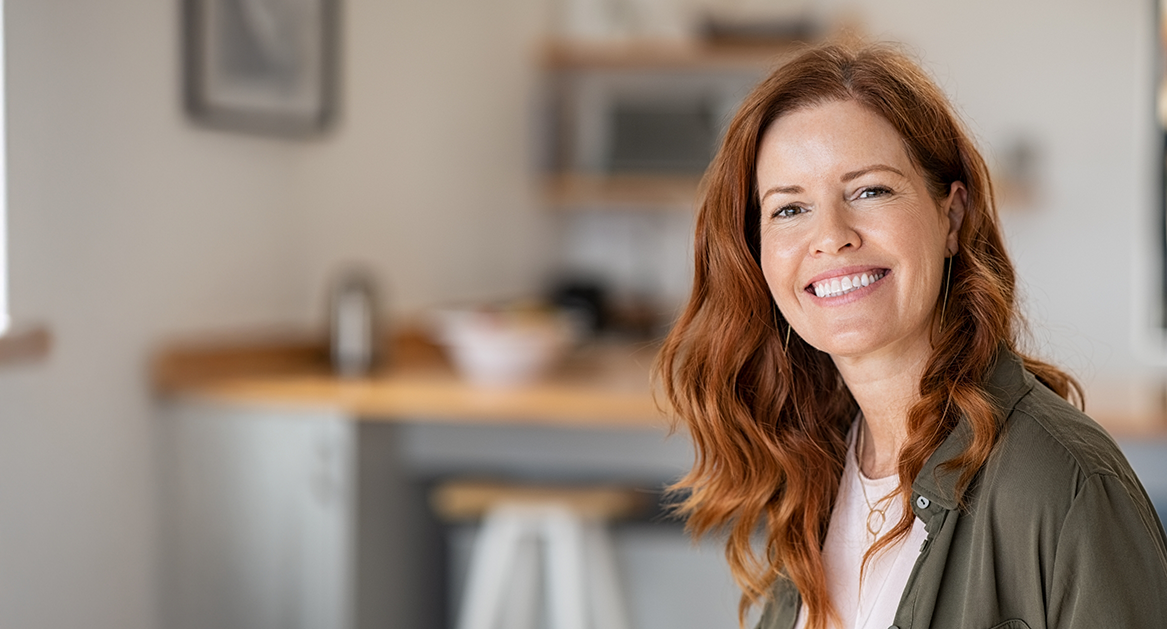 Woman with long wavy red hair smiling after cosmetic dentistry in Beaverton