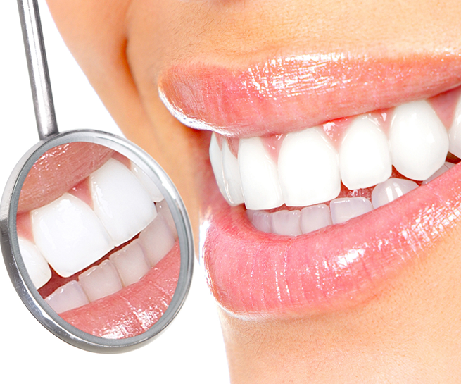 Close up of a dental mirror reflecting a smile with pristine white teeth