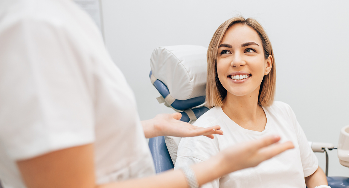 Woman in the dental chair talking to her dentist about dental implants in Beverton