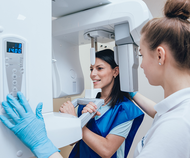 Woman getting a C T cone beam scan of her mouth and jaws