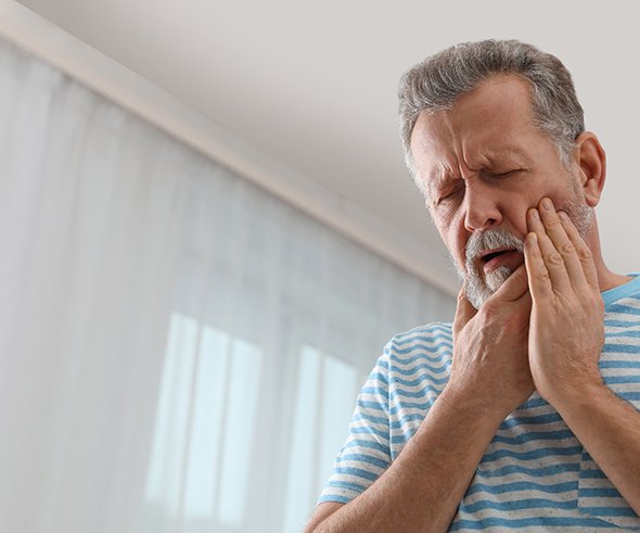 Man in striped shirt with tooth pain