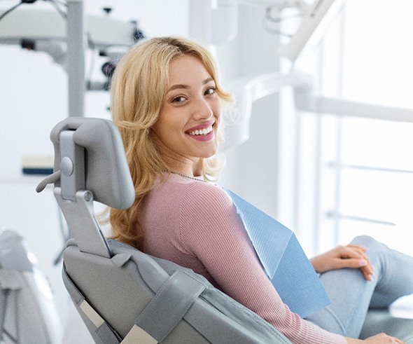 Blonde woman sitting in dental chair smiling