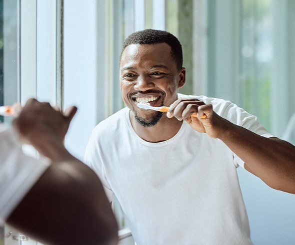Man in white shirt brushing his teeth