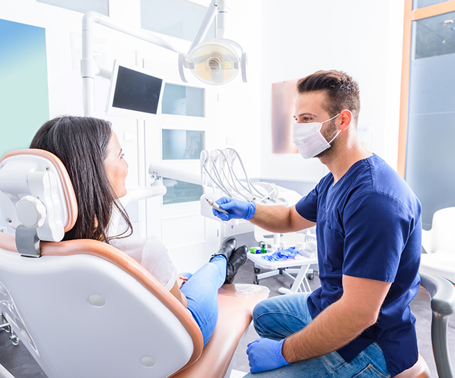 Woman in the dental chair chatting with her dentist