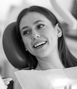 Woman in the dental chair smiling at her dentist