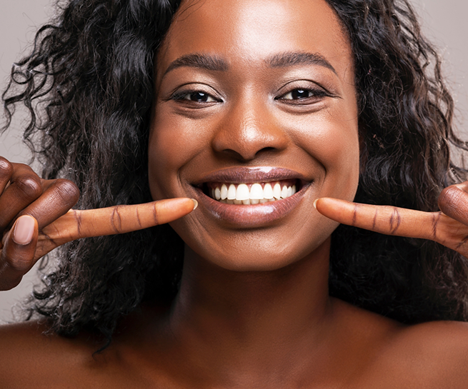 Woman pointing to her flawless smile