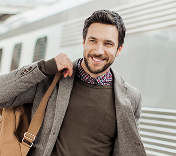 Man in an academic jacket holding a satchel