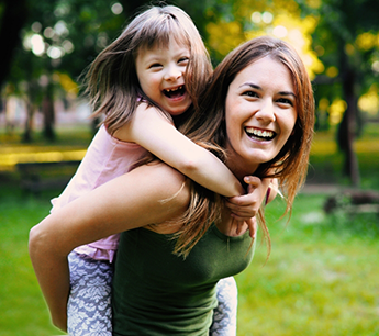 Woman carrying her young daughter on her shoulders