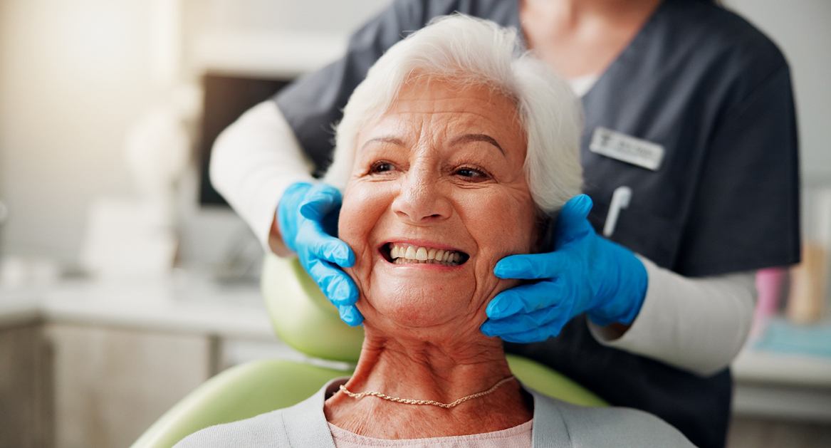 A dentist showing a patient a model of a dental implant