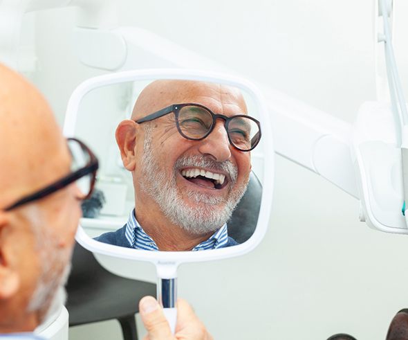 A man smiling after dental implant salvage