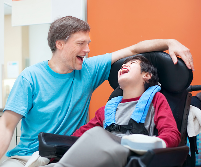 Dentist talking to a young boy patient in a wheelchair
