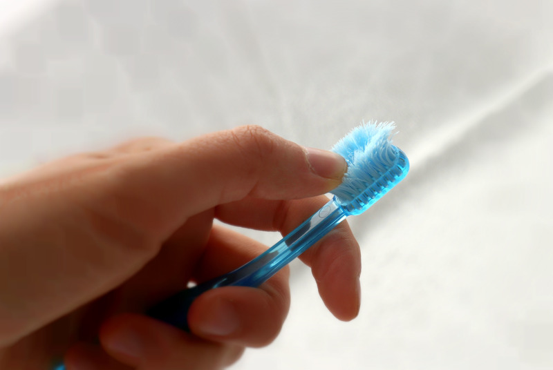 Patient with good oral health checking an old toothbrush