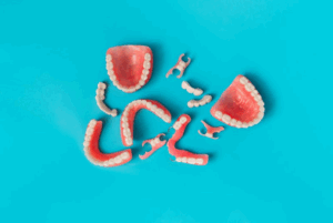 Various different dentures, partial dentures, and bridges scattered on a blue background