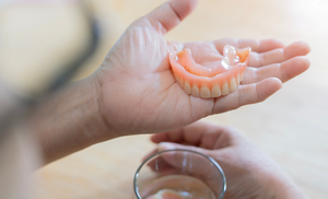 a dental patient examining their dentures